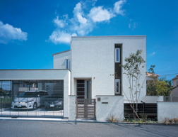 希望したスクエアのモダンな外観デザインが、閑静な住宅街の中でもひときわ目を惹くHさま邸。白と茶のツートン、塗り壁の外壁もお洒落な印象を与える青空に映える素敵な外観です