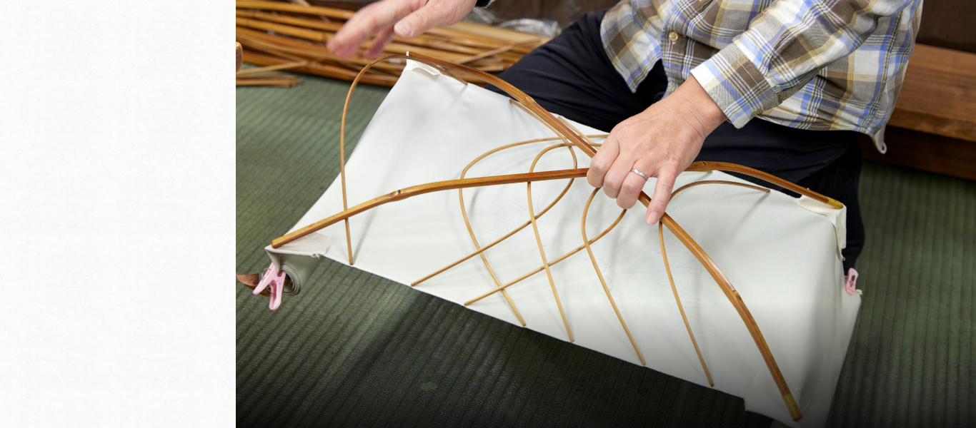 伸子と呼ばれる竹製の道具にぴんと布を張る。弾性があり、火に強い竹はこの作業に最良の素材だが、現在はこの道具に向く竹やつくり手が減っている。