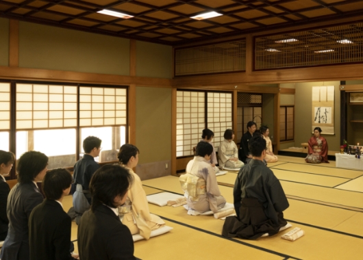 工房の試験に合格した弟子を祝う式の様子。田辺家の人々と弟子が正装して参加し、厳粛な雰囲気で執り行う。