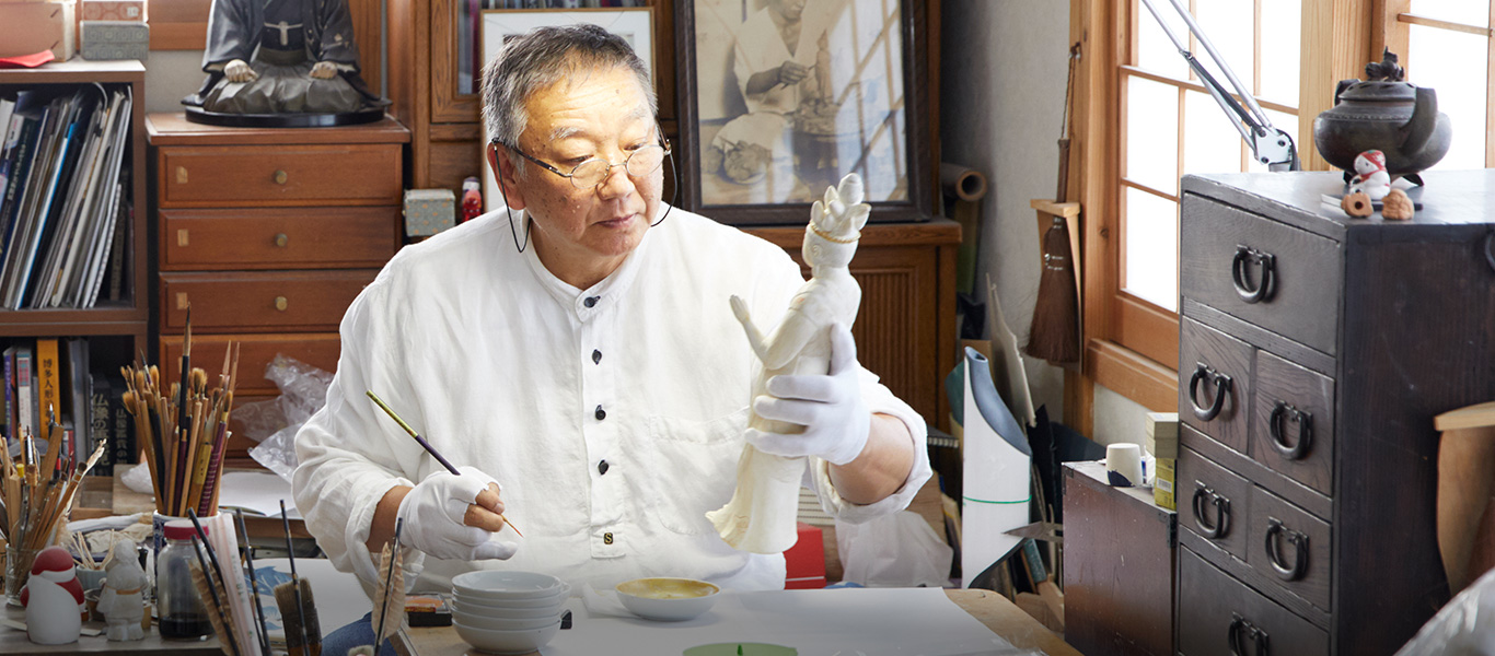 素焼きした人形に着色する。手本を見ながら、下絵なしで筆で塗っていく。顔を描く「面相」で人形の表情が決まる。