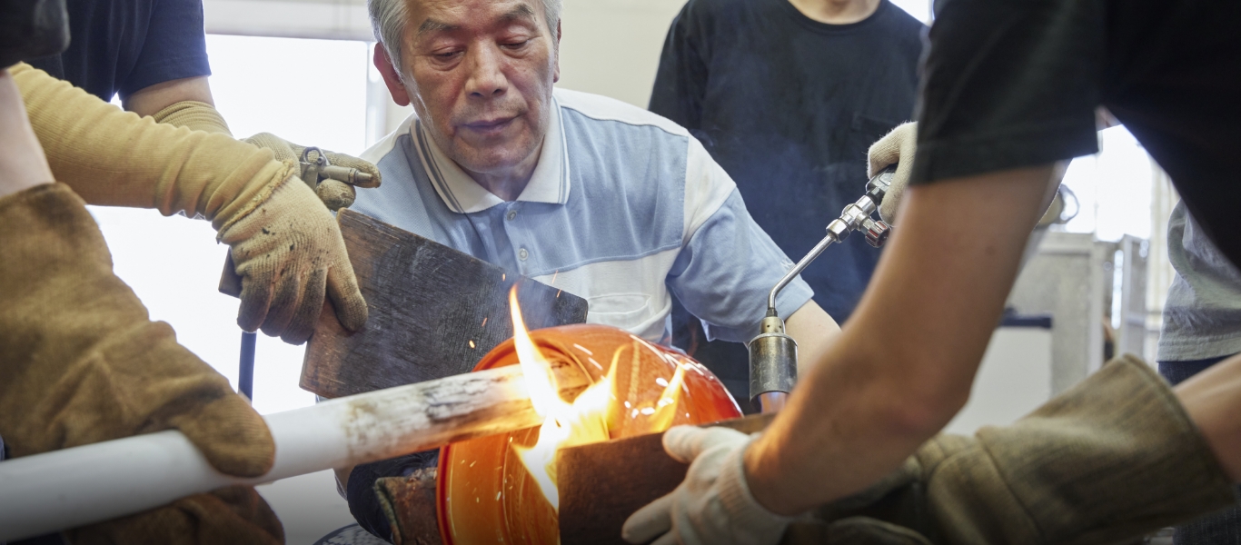 竿から外し、バーナーで焼きながら口の部分を開いていく。今まで内側だった部分が表側になる。