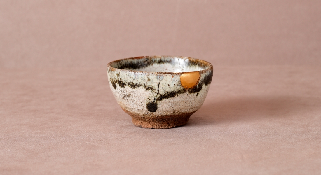 「斑皮鯨杯」
              皮鯨とは、唐津焼の茶盌やぐい呑みによくある口縁部を黒く縁取る装飾。歴代の所有者の愛情の証しである貫入や金継が器の魅力を高める。