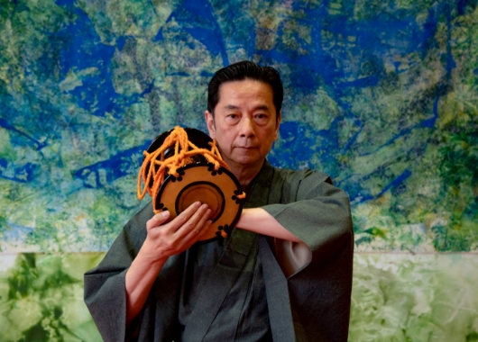 二十代のフランス公演旅行以来、親交のあった画家・松井守男氏の作品「光の森」を背景に。於 : EDOCCO 神田明神文化交流館