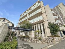 上品で清潔感のある白を基調とした外観。南傾斜の丘陵地に佇む4階建低層レジデンス。