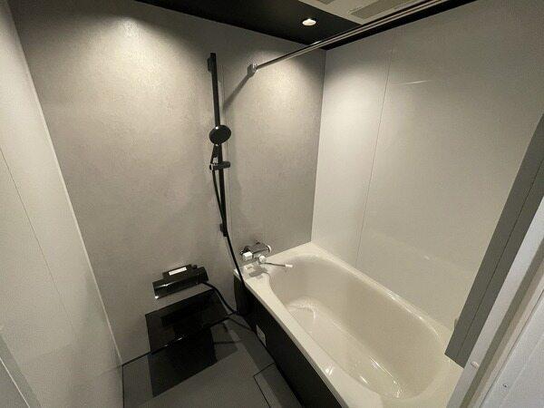 落ち着いた色味でまとめられた、洗練された印象の浴室。シャワーヘッドはスライドバーで高さ調節が可能。