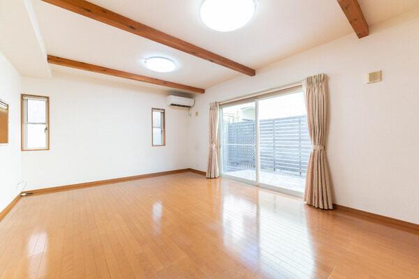 明るい2面採光設計。南東側の窓よりお庭に出入りできます。天井高は約2.6m、化粧梁が施されています。