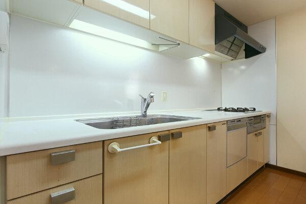 食器洗乾燥機搭載のシステムキッチン。吊戸棚や背面に設けられたカウンターなど収納力の高さも魅力です。