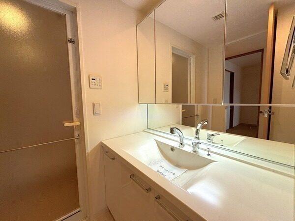 身支度がしやすい三面鏡と、ミドルミラーが備わった洗面化粧台。洗面室内にも収納が設けられています。