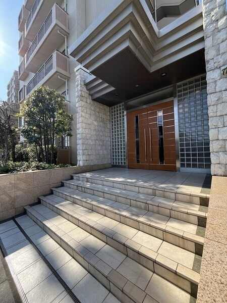 藤和不動産分譲・不動建設施工のマンション。エントランス周りには、豊かな植栽が施されています。
