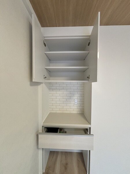 電源と複数の収納棚付のカップボードが備え付けられています。食器の収納や調理家電の配置に役立ちます。