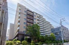 メインエントランス側。落ち着いたアースカラーのマテリアルを採用し、周囲の景観と調和する佇まいです。