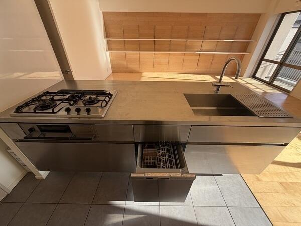 食器洗乾燥機や浄水器、3口コンロなどが備わった、機能性とデザイン性を兼ね備えたシステムキッチンです。