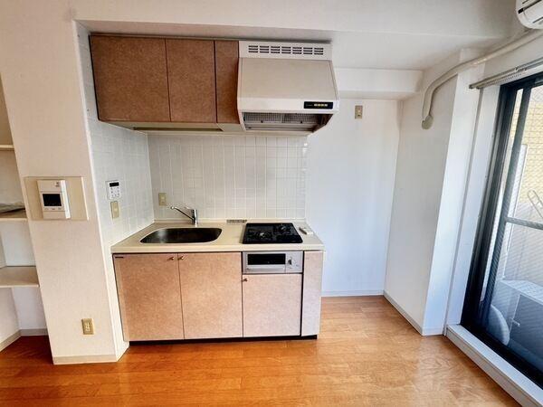 グリル付きの2口コンロが備わったシステムキッチン。吊戸棚が有り、調理器具などを収納できます。