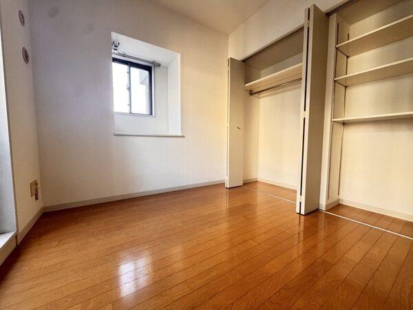 洋室の壁一面に収納が設けられています。ハンガーパイプや可動棚が備わり、すっきりと片付きそうです。