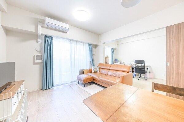 リビングダイニング（約10.7帖）に隣接する洋室（約4.5帖）の扉を開放し、約15.2帖の空間が完成