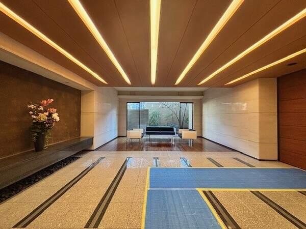 石敷きのフロアに木の持つ柔らかさと温かみを融合させた空間のエントランスホールとなります