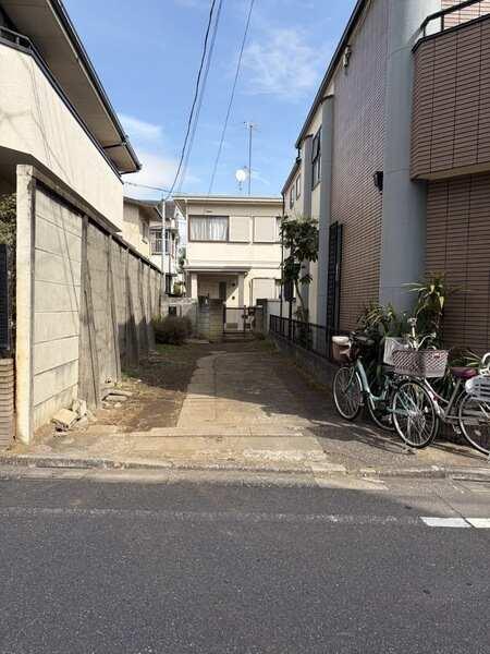 前面道路、左奥が物件となっております。