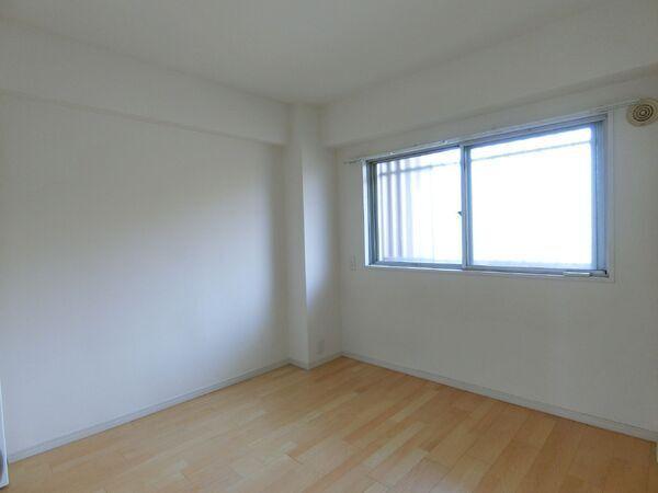 約5帖の洋室です。東側に腰高窓が設置され、ベッドなどの家具を壁付けに配置することができます。