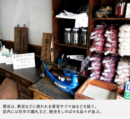 現在は、煮豆などに使われる菜豆やゴマ油などを扱う。店内には往年の鑑札など、歴史をしのばせる品々が並ぶ。