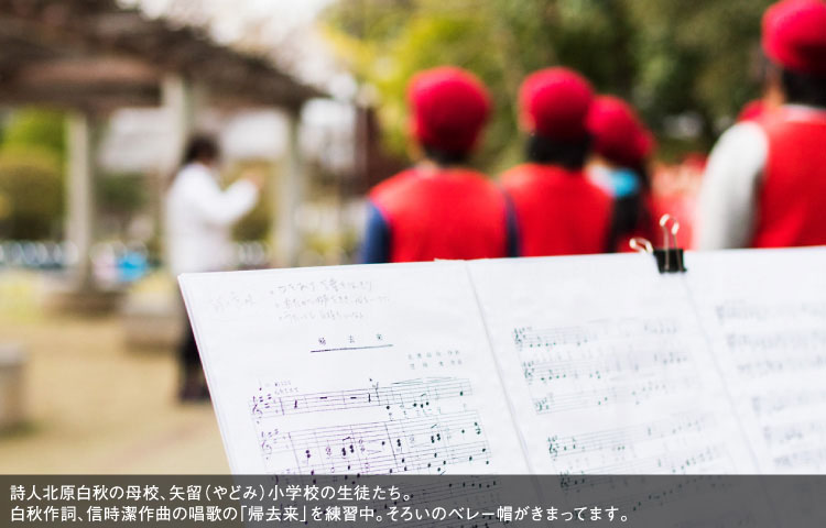 詩人北原白秋の母校、矢留（やどみ）小学校の生徒たち。白秋作詞、信時潔作曲の唱歌の「帰去来」を練習中。そろいのベレー帽がきまってます。