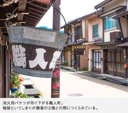 消火用バケツが吊り下がる職人町。袖壁というしきりが隣家の2階との間につくられている。
