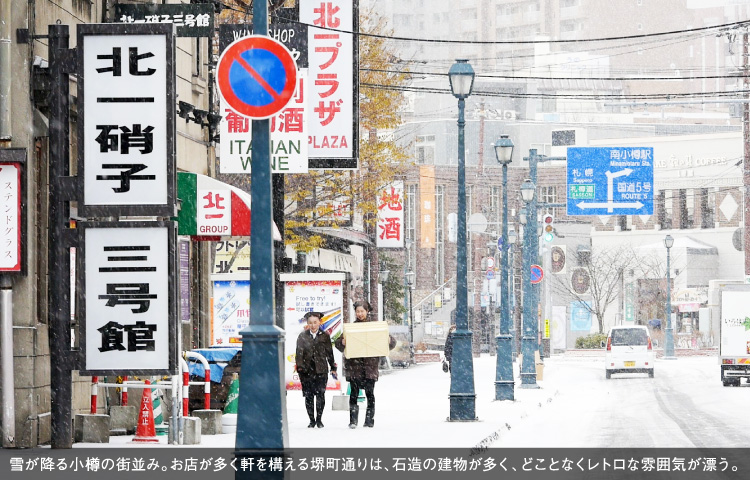 雪が降る小樽の街並み。お店が多く軒を構える堺町通りは、石造の建物が多く、どことなくレトロな雰囲気が漂う。