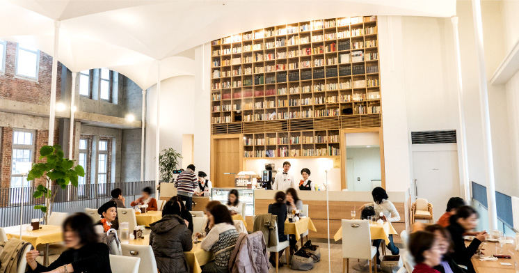 広々とした空間で、正面と背面の壁二面にそびえるライブラリーが印象的なカフェ。コンサートなどのイベントも不定期で行われる。