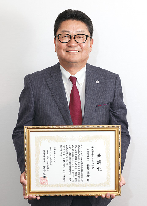 感謝状を持つ神緒会員